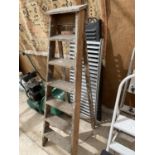 A SET OF VINTAGE SEVEN RUNG WOODEN STEP LADDERS, A PAIR OF METAL RAMPS ETC
