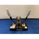 A PRESENTATION PENREST STAND WITH TWO PEN HOLDERS AND DOG DECORATION