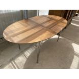 AN OVAL TEAK DINING TABLE ON CHROME SUPPORTS