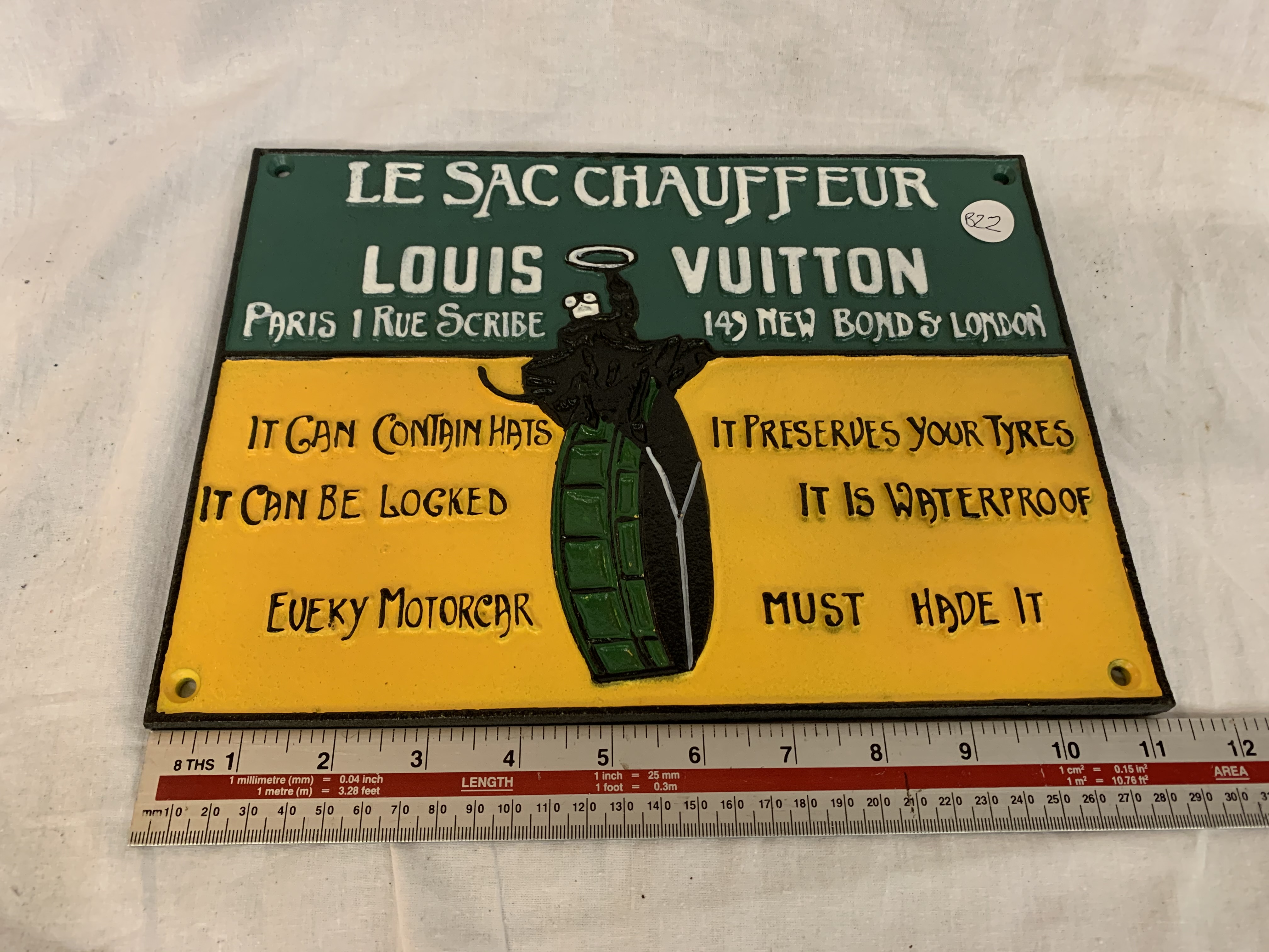 A CAST LE SAC CHAUFFEUR LOUIS VUITTON SIGN 11 INCHES BY 8 INCHES