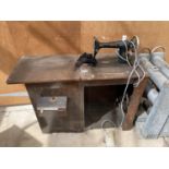 AN ELECTRIC SINGER SEWING MACHINE IN A WOODEN CABINET WITH INNER STORAGE BOX IN WORKING ORDER