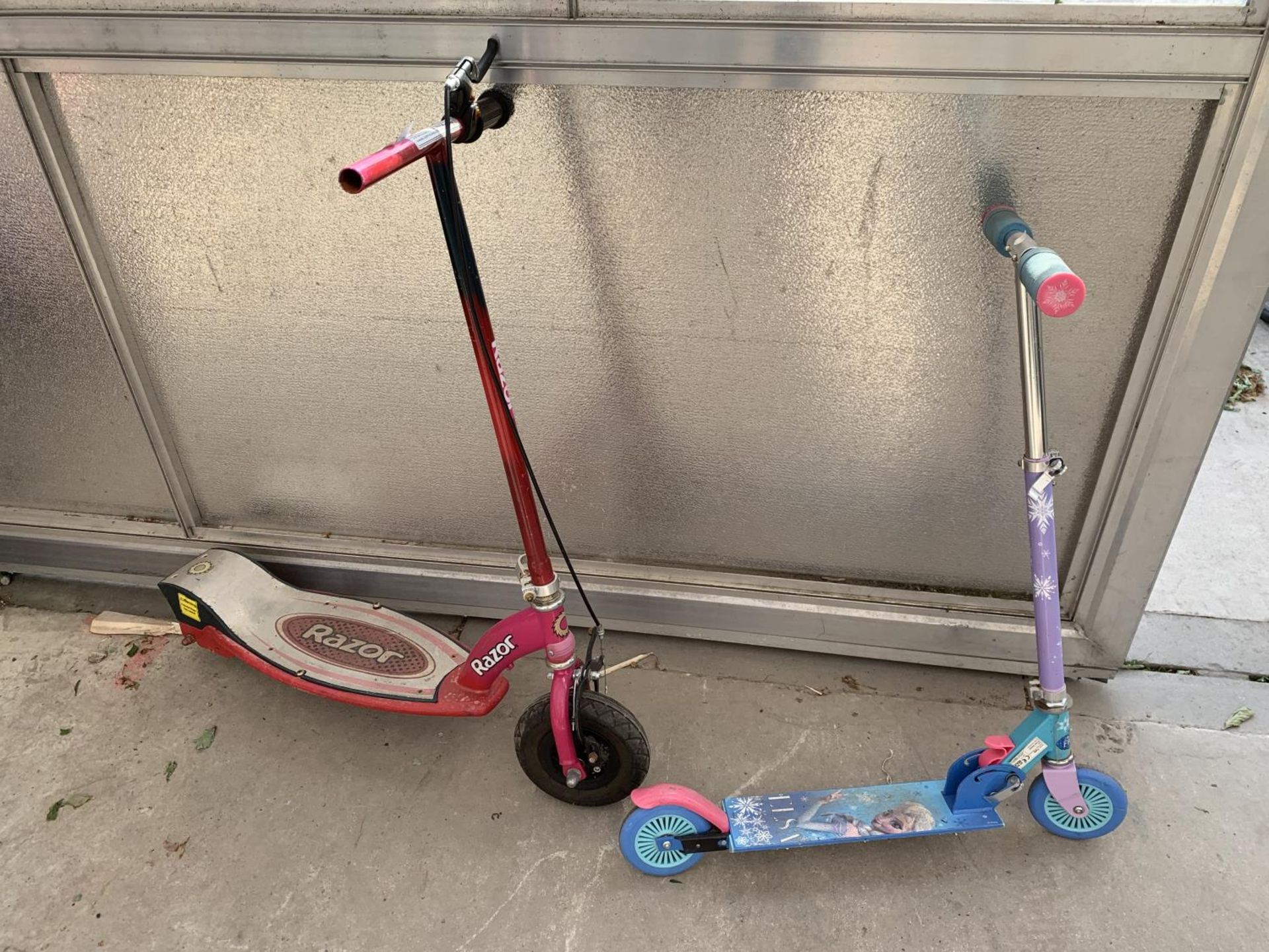 A RED RAZOR SCOOTER AND A FROZEN SCOOTER