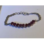 A SILVER BRACELET SET WITH NINE OVAL RUBIES (RUBY WEIGHT 7.11 CARAT)
