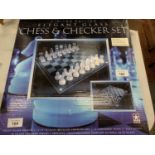 A NEW AND BOXED LIMITED EDITION ELEGANT GLASS CHESS AND CHECKER SET