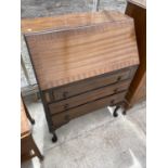 A MAHOGANY BUREAU ON CABRIOLE SUPPORTS WITH FALL FRONT AND THREE DRAWERS