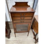 A MAHOGANY MUSIC CABINET ON TAPERED SUPPORTS WITH GLAZED LOWER DOOR AND THREE DRAWERS, TWO HAVING