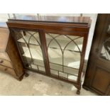 A MAHOGANY CABINET ON BALL AND CLAW FEET WITH TWO DOORS AND GLAZED SIDE PANELS