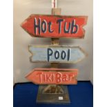 A WOODEN 'TIKI BAR, HOT TUB, POOL' DIRECTION SIGN