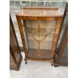 AN ART DECO STYLE WALNUT CABINET ON CABRIOLE SUPPORTS WITH GLAZED DOORS AND SIDE PANELS