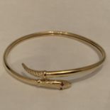 A 9 CARAT GOLD SNAKE BANGLE WITH RED STONE SET EYES. TOTAL GROSS WEIGHT 8.7 GRAMS