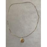 A LOCKET MARKED "TESTED 9 CARAT GOLD FRONT & BACK" ON A YELLOW METAL NECKLACE (70 CM) - LOCKET