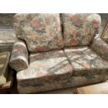 A FLORAL TWO SEATER SOFA