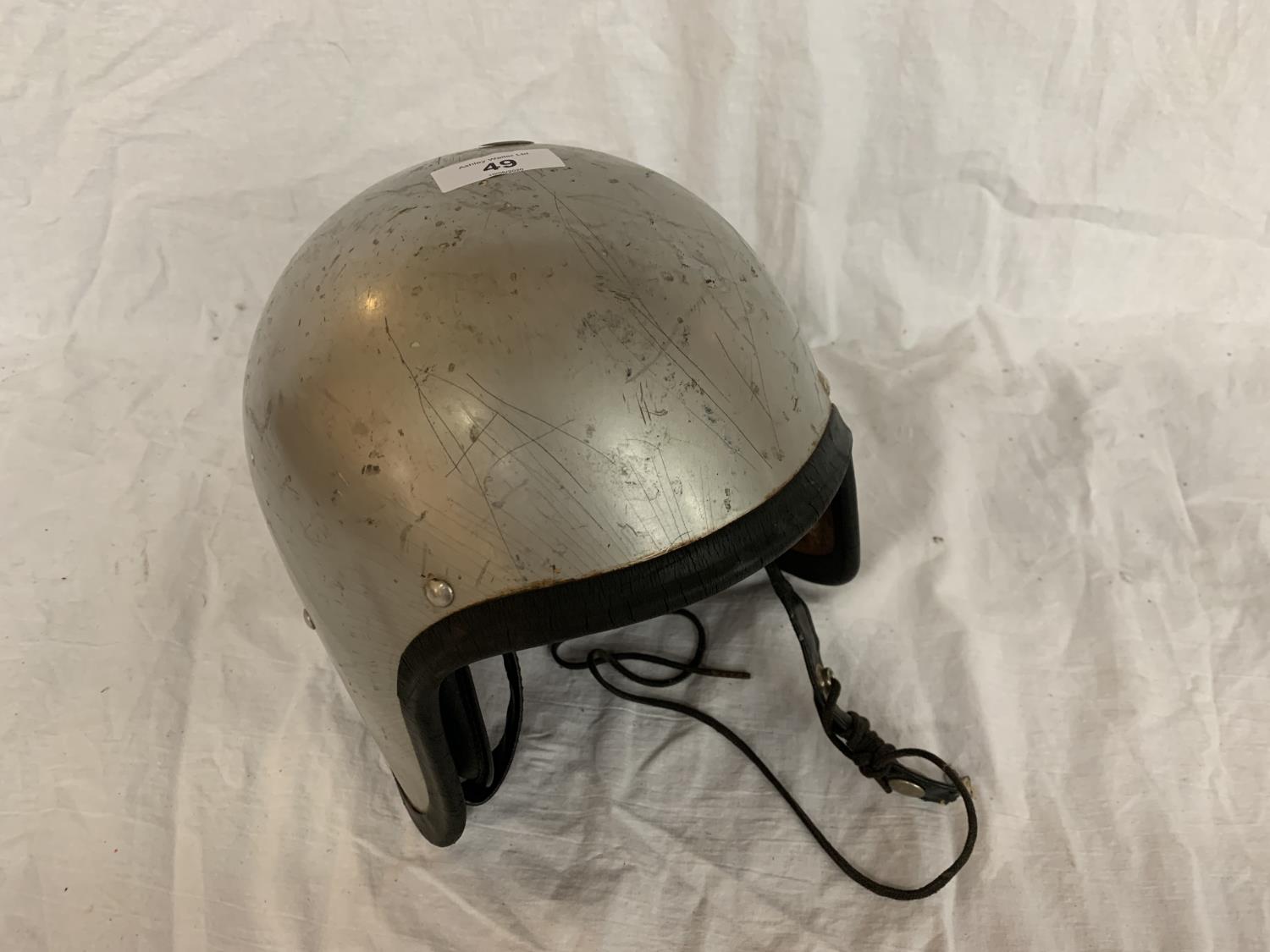 A VINTAGE SILVER COLOURED CRASH HAT