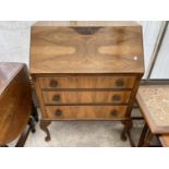 A WALNUT BUREAU ON CABRIOLE SUPPORTS WITH FALL FRONT, THREE DRAWERS AND INNER RED LEATHER WRITING