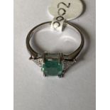 A 9 CARAT WHITE GOLD, DIAMOND AND EMERALD RING (0.06 CARAT) - RING SIZE M+