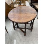 AN OVAL OAK DROP LEAF SIDE TABLE ON BARLEY TWIST SUPPORTS