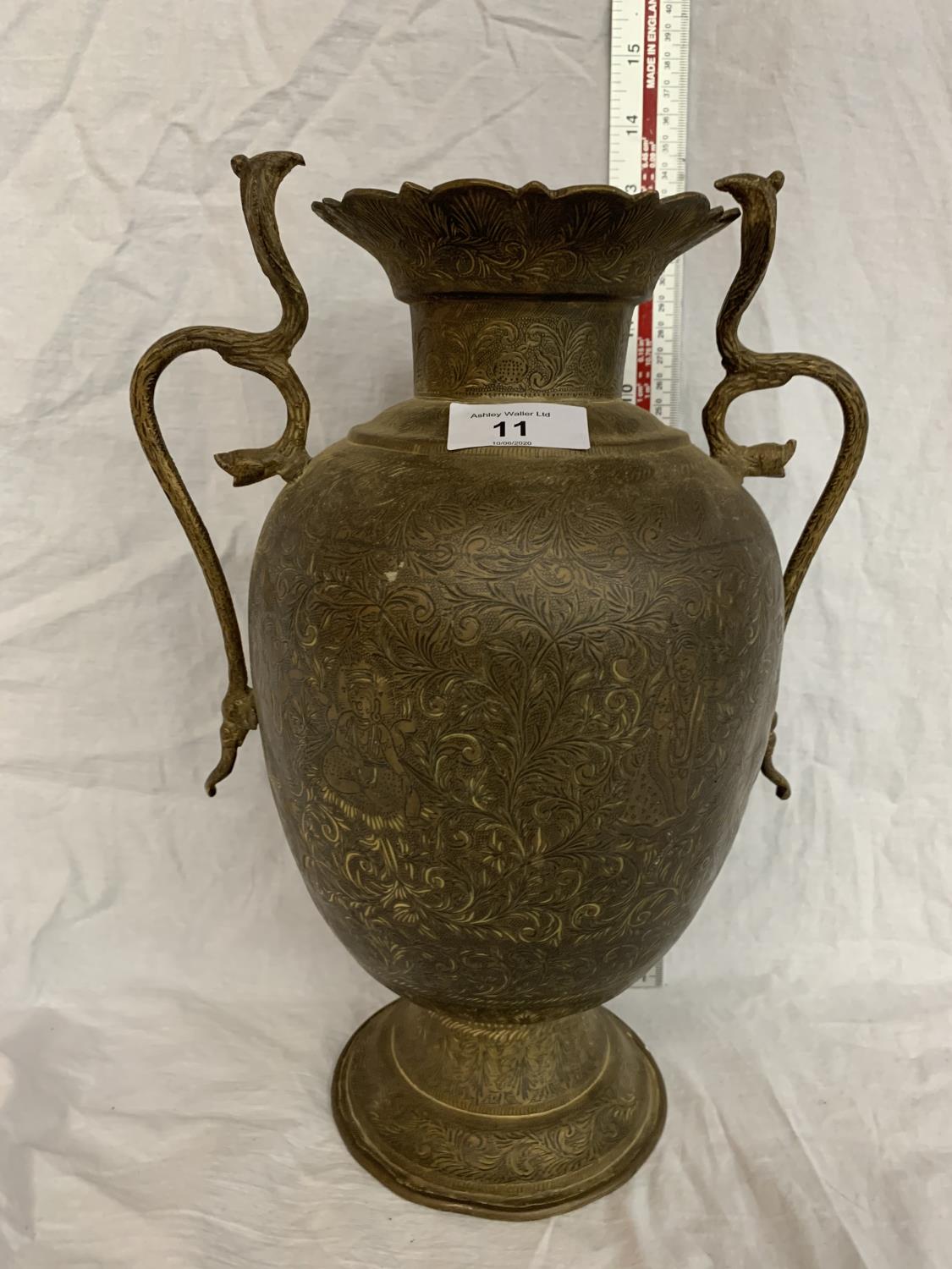 A TALL BRASS VASE WITH COBRA STYLE HANDLES