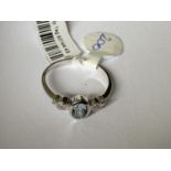 A 9 CARAT WHITE GOLD RING WITH CENTRE AQUAMARINE AND TWO DIAMOND CHIPS (0.01 CARAT) - RING SIZE M+