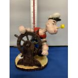 A CAST IRON POPEYE WITH A SHIPS WHEEL FIGURE