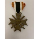 A GERMAN 1939 MERIT CROSS WITH CROSSED SWORDS AND RIBBON