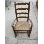 A CHILD'S OAK LADDER BACK ROCKING CHAIR WITH RUSH SEAT