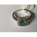 A 9 CARAT WHITE GOLD, DIAMOND AND EMERALD RING (0.04 CARAT) - RING SIZE N