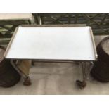 AN INDUSTRIAL METAL FRAMED TROLLEY WITH TRAY TOP ON WHEELS