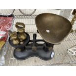 A SET OF CAST AND BRASS KITCHEN SCALES AND FIVE BRASS BELL WEIGHTS