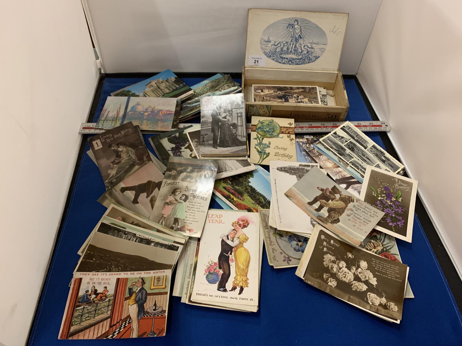 A LARGE COLLECTION OF POSTCARDS IN A CIGAR BOX