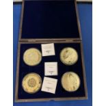 A BOXED SET OF FOUR LARGE LIBERTY COINS DEPICTING THE MAYAN CALENDAR AND GOLD GIANTS