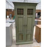 A TALL GREEN PAINTED PINE BEDROOM CABINET WITH TWO DOORS AND INNER SHELVING