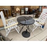 A BLACK CIRCULAR GARDEN TABLE WITH PARASOL BASE AND TWO WHITE RECLINER CHAIRS