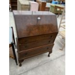 A WALNUT BUREAU ON CABRIOLE SUPPORTS WITH FALL FRONT AND THREE DRAWERS