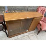 A RETRO TEAK BOOKCASE CABINET WITH ONE DOOR AND TWO SLIDING GLASS DOORS