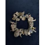 VINTAGE WHITE METAL CHARM BRACELET WITH SEVERAL SILVER CHARMS TOTAL GROSS WEIGHT 62 GRAMS