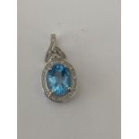 A 9 CARAT WHITE GOLD PENDANT WITH CENTRE OVAL CUT AQUAMARINE AND DIAMOND CHIPS. WEIGHT 1.5 GRAMS.