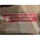 A PINK 'NOBODY PUTS BABY IN THE CORNER' SIGN
