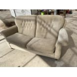 A BEIGE TWO SEATER SOFA
