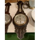 AN ORNATE WOODEN CASED BAROMETER