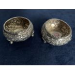PAIR OF ANGLO INDIAN WHITE METAL EMBOSSED SALT SELLARS WITH ELEPHANT, HARE AND FOREST SCENES,