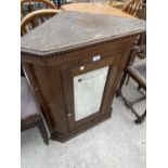 AN OAK FLAT FRONT CORNER CUPBOARD WITH BEVEL EDGE MIRRORED DOOR