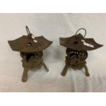 A PAIR OF CAST PAGODA STYLE TEA LIGHT CANDLE HOLDERS