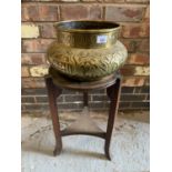 A LARGE ASIAN BRASS BOWL ON A TABLE