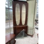 A LARGE ANTIQUE OAK CORNER CABINET WITH TWO LOWER DOORS AND TWO UPPER GLAZED DOORS