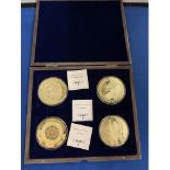 A BOXED SET OF FOUR LARGE LIBERTY COINS DEPICTING THE MAYAN CALENDAR AND GOLD GIANTS