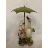 A PAIR OF WOODEN DUCKS WITH AN UMBRELLA