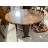 AN OVAL OAK DROP LEAF SIDE TABLE