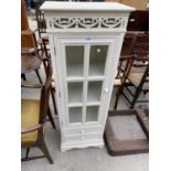 A WHITE CABINET WITH TWO DRAWERS, GLAZED PANEL DOOR AND FRETWORK DECORATION