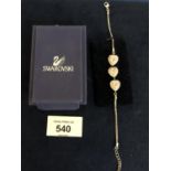 A MODERN SILVER SWAROVSKI PINK & WHITE STONE THREE STONE HEART BRACELET, MARKED 925. BOXED