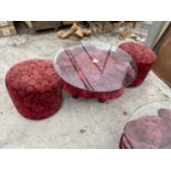 A RED ROSE PATTERNED GLASS TOP TABLE AND TWO MATCHING STOOLS